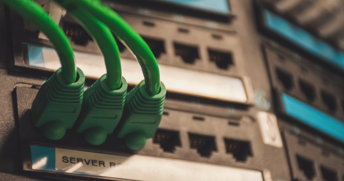 Des serveurs informatiques dans un datacenter écologique, éclairés par des lumières vertes symbolisant l'énergie renouvelable et l'efficacité énergétique.